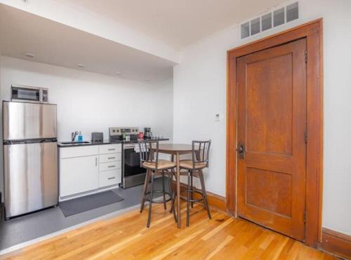 a kitchen with a table and a refrigerator at Beautiful 1 Bed Studio Apt Close To Hospitals! in Des Moines