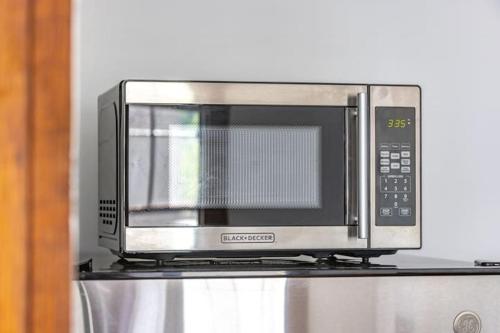 a microwave oven sitting on top of a refrigerator at Beautiful 1 Bed Studio Apt Close To Hospitals! in Des Moines
