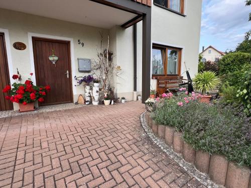 a brick walkway leading to a house with flowers at Ferienwohnung Dörfler in Hollfeld