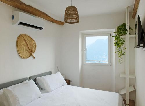 a bedroom with a white bed and a window at LevOasi 7 - Garden, jacuzzi and sauna escape in Levo