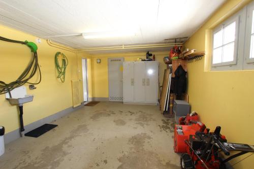 a room with a garage with yellow walls at Chalet Les Arolles in Chateau-d'Oex