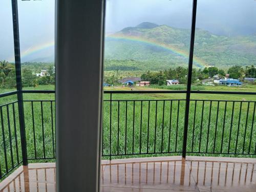 a view of a rainbow from a balcony at Le Sancta homestay in Marayoor