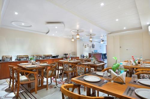 a dining room with wooden tables and chairs at Trim Boutique Parkota Haveli in Jaipur