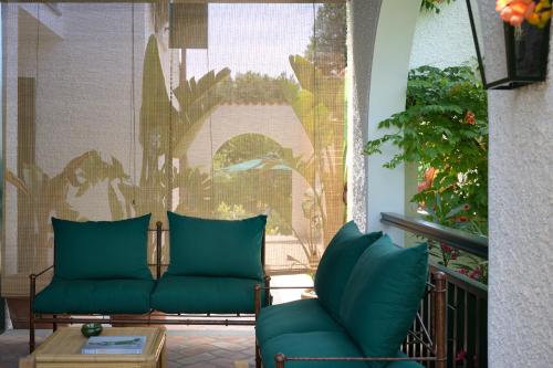 a living room with two green chairs and a table at California Park Hotel in Forte dei Marmi