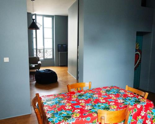 une table à manger avec un tissu de table fleuri dans l'établissement Cœur Du Marais - Grand appartement 2 chambres, à Paris