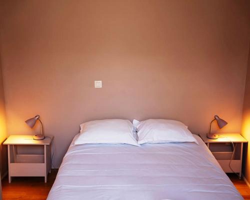 une chambre avec un lit avec deux lampes sur deux tables dans l'établissement Cœur Du Marais - Grand appartement 2 chambres, à Paris