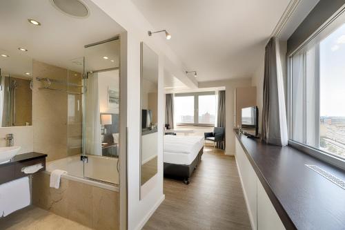 a hotel room with a bed and a bathroom at Park Inn by Radisson Berlin Alexanderplatz in Berlin