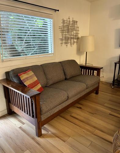 a couch in a living room with a window at Classic & Cozy Apartments - Parking & Close To Dw in Medford