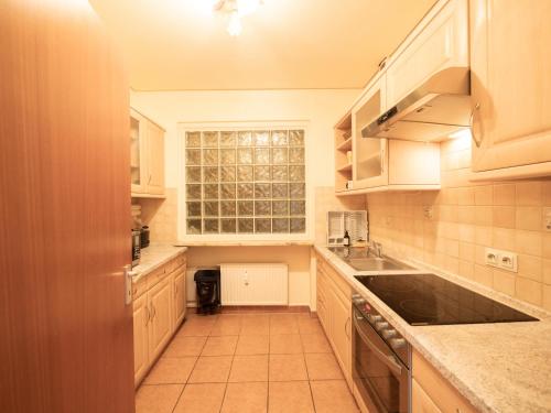 a large kitchen with white cabinets and a window at Palatium Bad Ems in Bad Ems