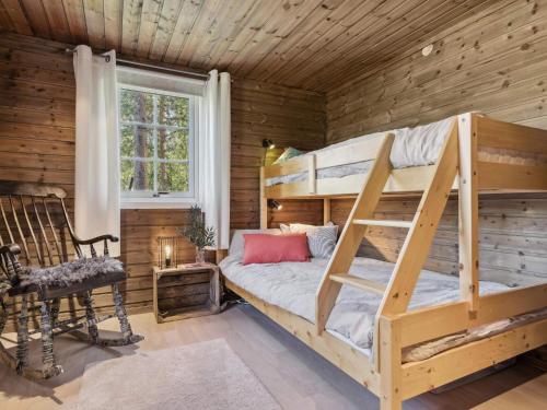 - une chambre avec des lits superposés dans une cabane en rondins dans l'établissement 4 star holiday home in Storsteinnes, à Rundhaug