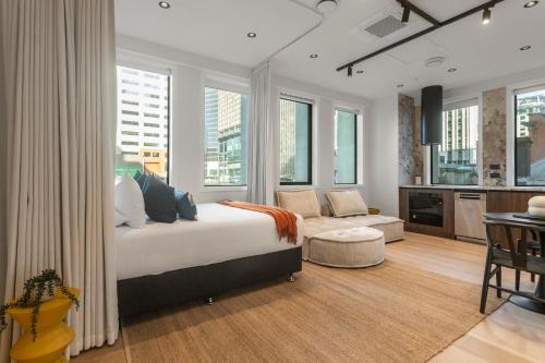 a bedroom with a bed and a living room at Victoria Street Apartments by Urban Rest in Auckland