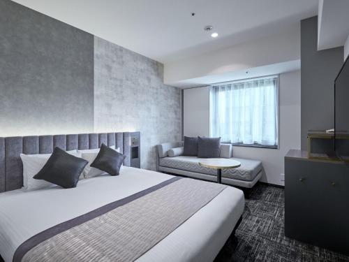 a bedroom with a large bed and a couch at Hotel Villa Fontaine Grand Tokyo-Shiodome in Tokyo