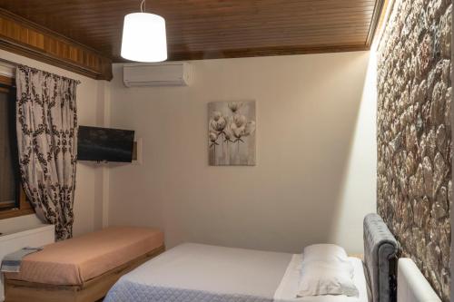 a small room with a bed and a tv at Liontos Rooms in Pramanta