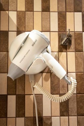 a white rotary phone is hanging on a wall at Liontos Rooms in Pramanta