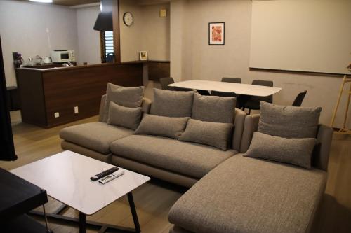 a living room with a couch and a table at ritomaru rooms hakata hakozaki in Fukuoka