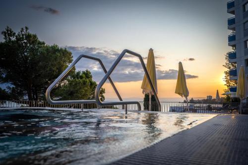a swimming pool with umbrellas next to the water at Hotel Mona Ex-Eurotel in Montreux