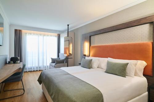 a hotel room with a large bed and a desk at Gran Hotel Luna de Granada in Granada