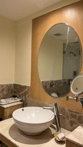 a bathroom with a white sink and a mirror at Katriya Hotel and Tower in Hyderabad