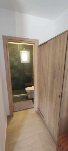 a bathroom with a toilet and a glass door at Αλκυονη Διαμερισματα in Paralia Vrachou