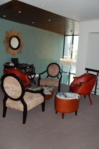 a room with chairs and tables and a mirror at Isango Gate in Port Elizabeth