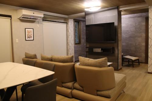 a living room with a couch and a table at ritomaru rooms hakata hakozaki in Fukuoka