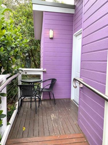 a purple house with a table and chairs on a porch at Huskisson Beach Escape in Huskisson
