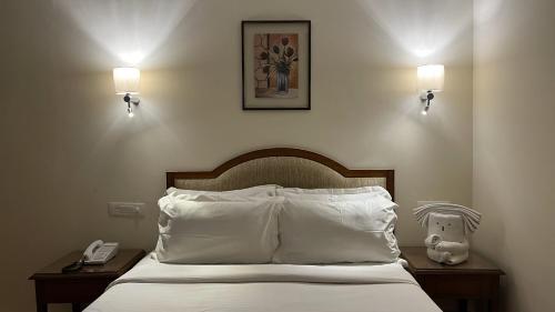 a bedroom with a bed with pillows and a phone at Katriya Hotel and Tower in Hyderabad