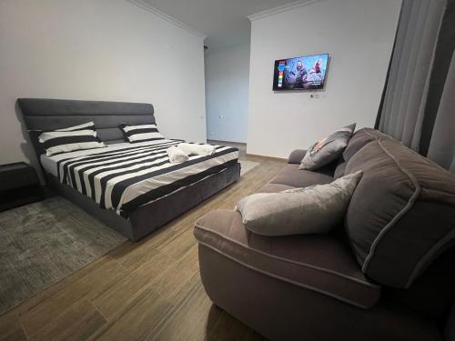 a living room with a bed and a couch at Residencial Costa do Sol Nr 50 in Maputo