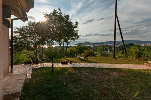 a park with a bench and a tree and the sun at Bitrak House Megdani in Ohrid