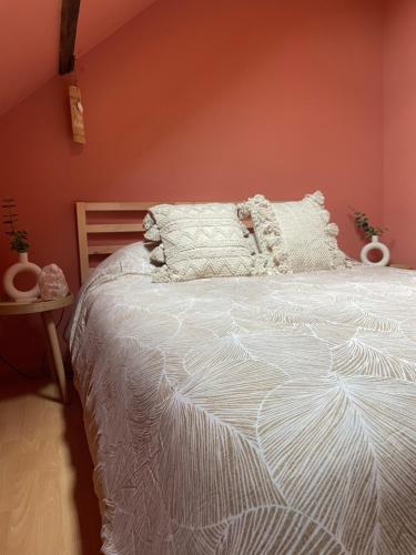 une chambre avec un lit blanc avec un mur rouge dans l'établissement Maison Spacieuse Jacuzzi Wifi Netflix, à Quiévrechain