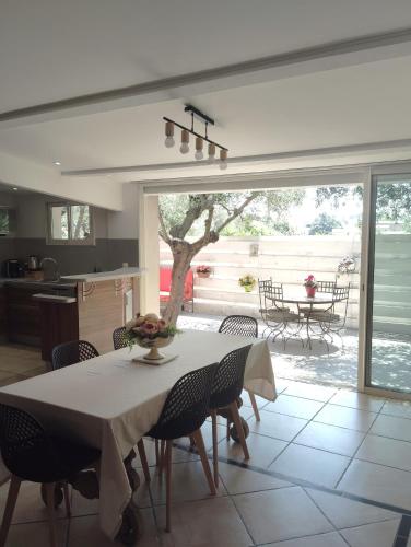 une cuisine et une salle à manger avec une table et des chaises dans l'établissement Magnifique Villa aux Oliviers trentenaires, à Mougins