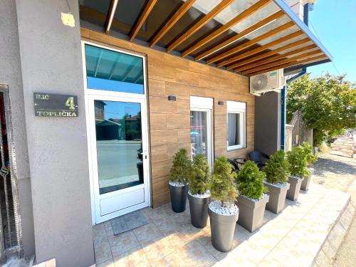 a row of potted plants in front of a building at LAGUNA Apartments in Vranje