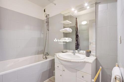 a white bathroom with a sink and a bath tub at Ô Carré d'Or - T3 proche du centre ville- Saint-Denis in Saint-Denis