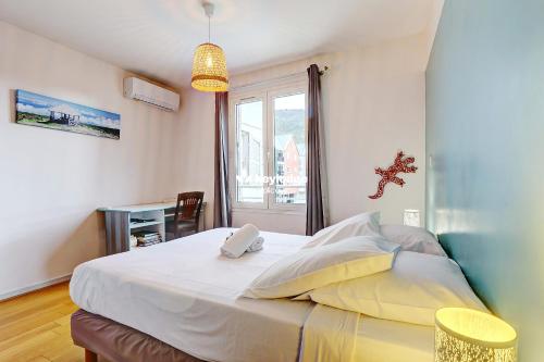 a bedroom with a large white bed with a window at Ô Carré d'Or - T3 proche du centre ville- Saint-Denis in Saint-Denis