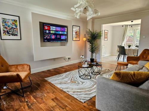 a living room with a couch and a tv on a wall at Glasgow Green Modern Stay in Glasgow