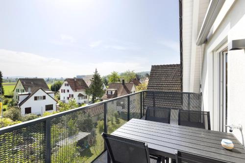 a balcony with a table and chairs and a view at STAYY Flagship Limmattal - contactless check-in in Schlieren