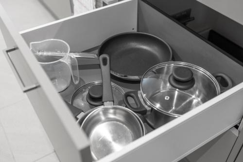 a drawer filled with pots and pans in a kitchen at STAYY Flagship Limmattal - contactless check-in in Schlieren
