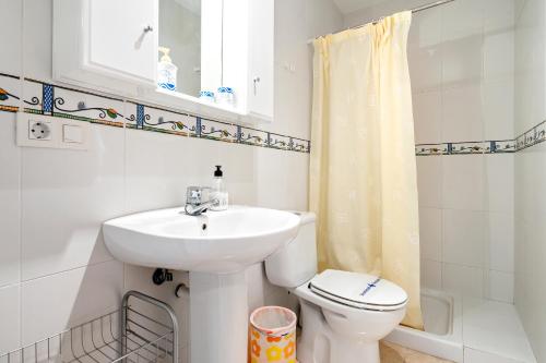 a white bathroom with a sink and a toilet at Cap Roig, Appartement Duplex in L'Ampolla