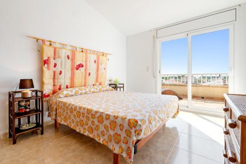 a bedroom with a bed and a large window at Cap Roig, Appartement Duplex in L'Ampolla