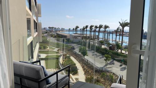 a balcony with a view of the ocean and palm trees at Marassi, Luxury Suite in Address Beach resort! service apartment in El Alamein