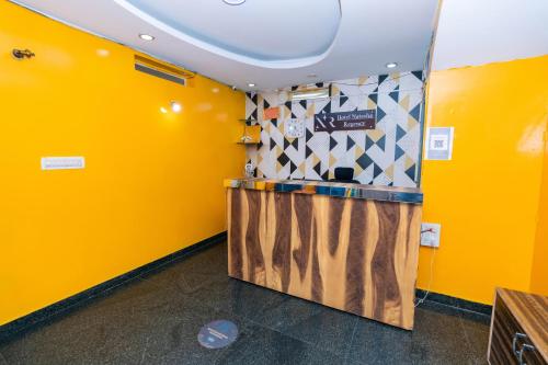 a bar in a yellow room with a yellow wall at Hotel Natasha Regency Bangalore Airport in Bengaluru