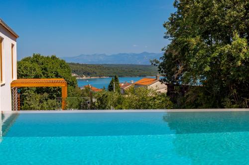 索利纳Villa 4 with Pool Soline, Krk, 280 m from beach, by 4Villas的享有湖景的大型蓝色游泳池