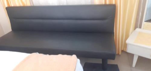 a bed with a black foot board in a bedroom at Cottage on 14th in East London