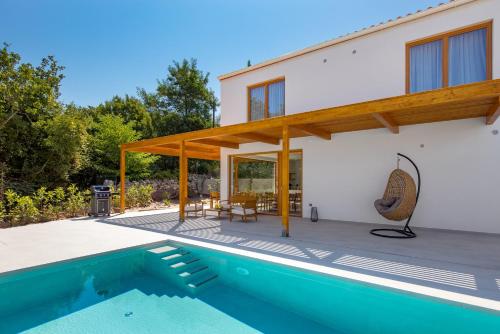 索利纳Villa 4 with Pool Soline, Krk, 280 m from beach, by 4Villas的一栋前面有游泳池的房子