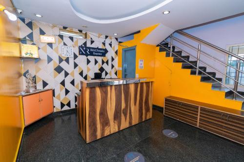 a lobby with a staircase and a yellow wall at Hotel Natasha Regency Bangalore Airport in Bengaluru