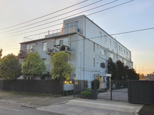 a tall white building with a fence in front of it at Royal Park Retreat in Melbourne