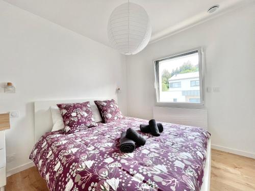 - une chambre avec un lit doté d'une couette violette et d'une fenêtre dans l'établissement LA VILLA CAP COZ - 3 Chambres - Plage à 800 m, à Fouesnant