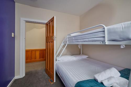 a bedroom with a bunk bed with a ladder at Villa Family Friendly Classic Charm in Kaikoura