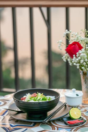 a bowl of salad sitting on a table with a plate at Central Westlake Residence 2 - By Pegasy Group in Hanoi
