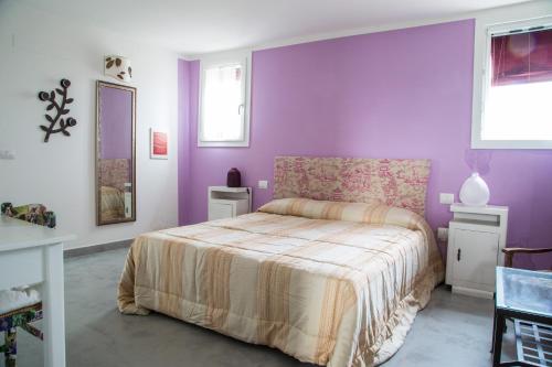 a bedroom with purple walls and a bed in it at B&B Ai Prati in Monestirolo